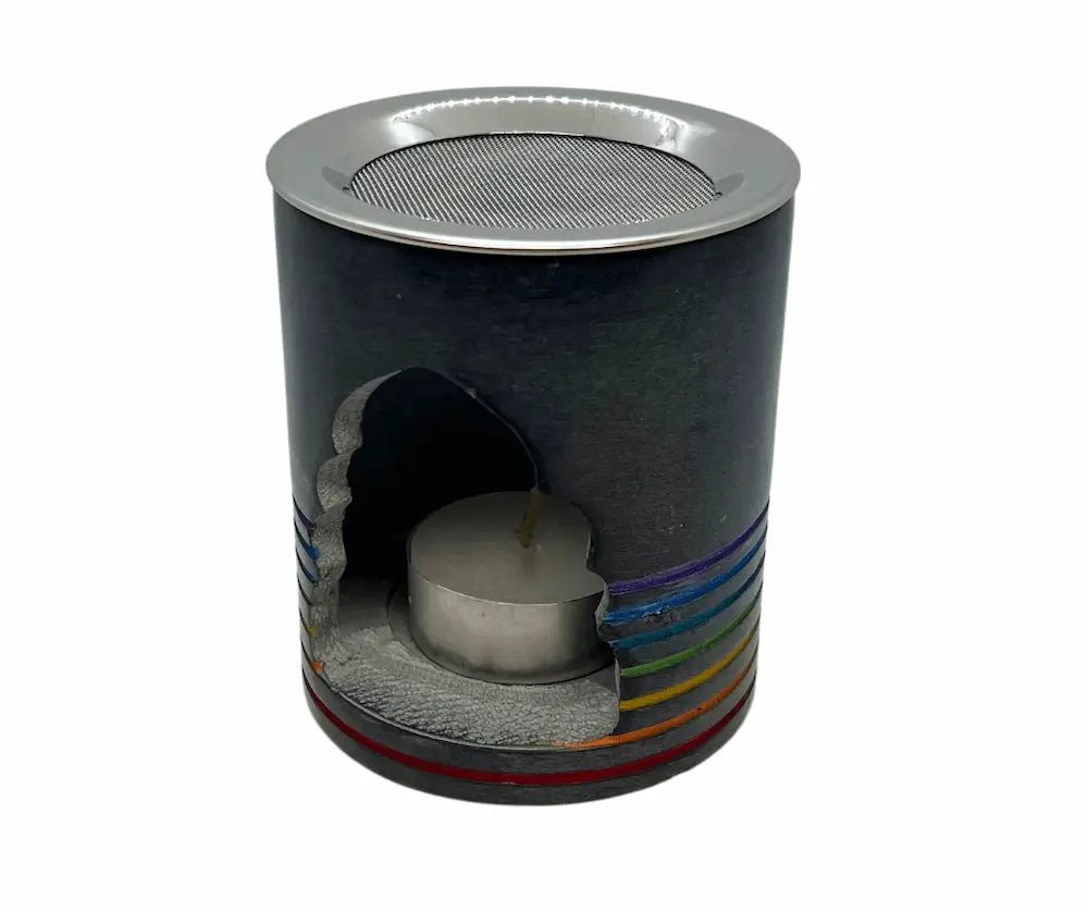 Zylindrischer Weihrauchbrenner aus dunklem Speckstein mit Metallsieb, Teelicht im Inneren und Regenbogen-Chakrastreifen am unteren Rand