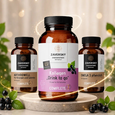 Drei braune Zaversky Stadtapotheke Glasflaschen mit Kollagen Drink to go, Arthrowell und Omega 3 pflanzlich auf Steinpodest mit schwarzen Johannisbeeren