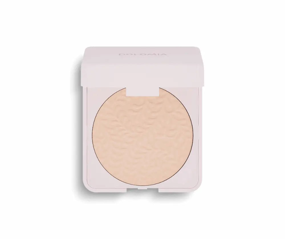 Geöffnetes Dolomia Kompaktpuder in heller Nude-Nuance mit verziertem Blattmuster in rosafarbener Dose, Vorderansicht.